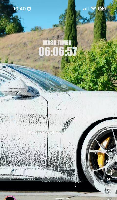 Reel: a white sports car being hand-washed, wash timer overlay